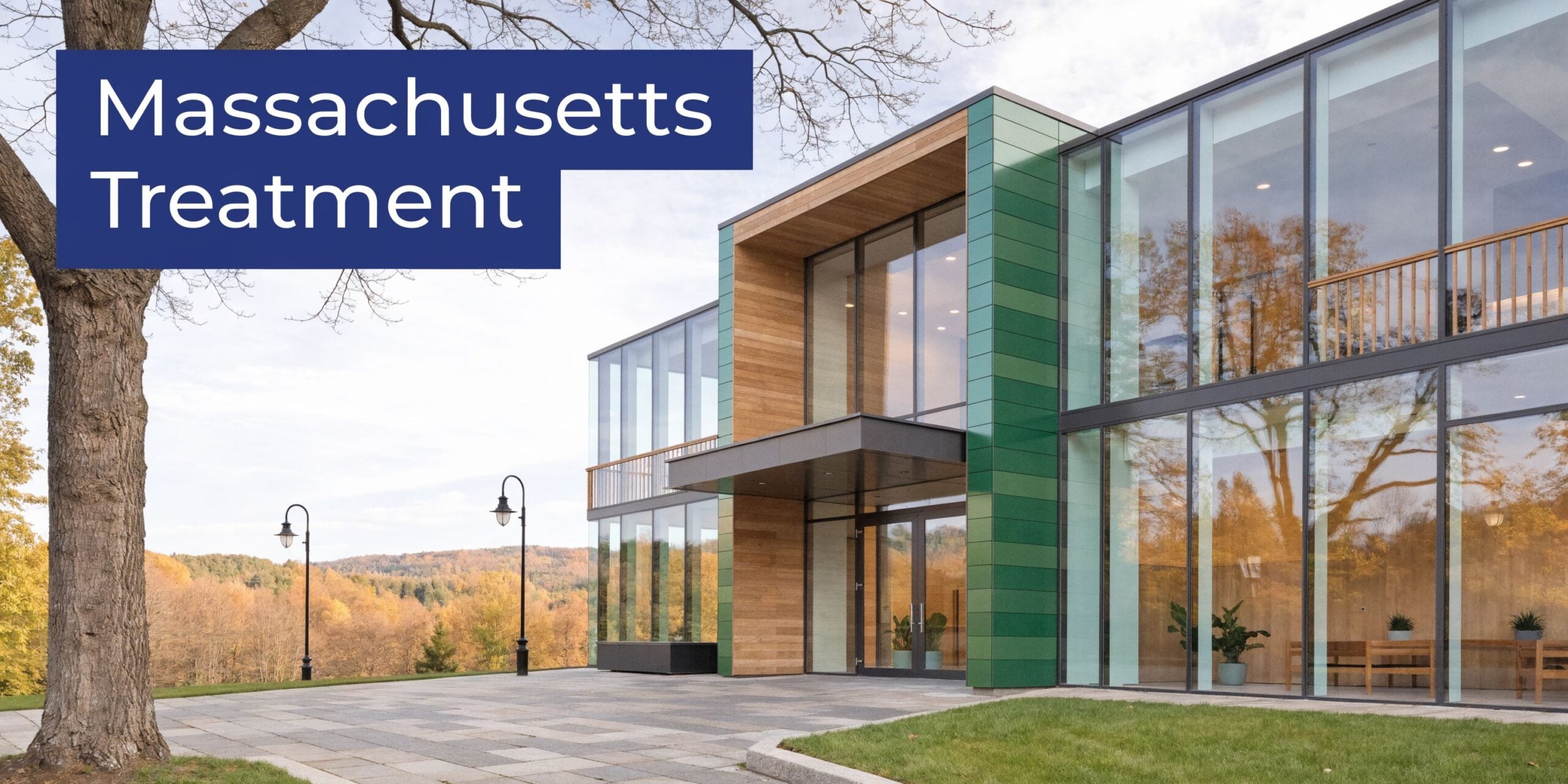 A modern building with large glass walls and green panels situated in a scenic landscape setting.