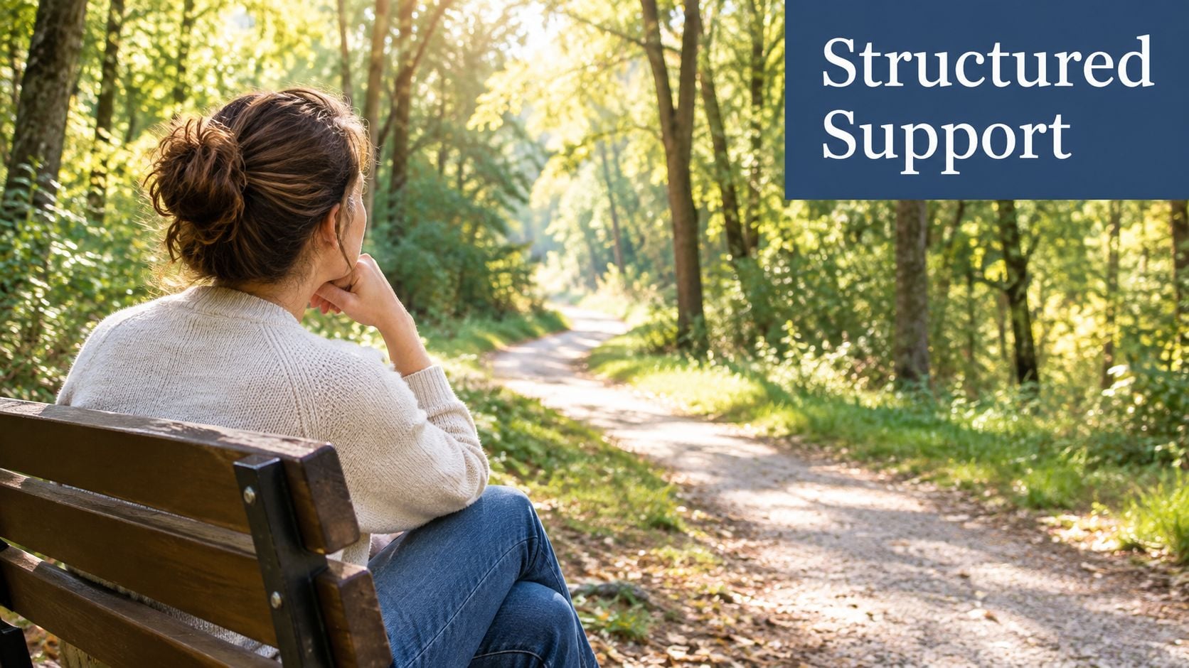 A woman sitting on a wooden bench in a peaceful forest, contemplating the path ahead.